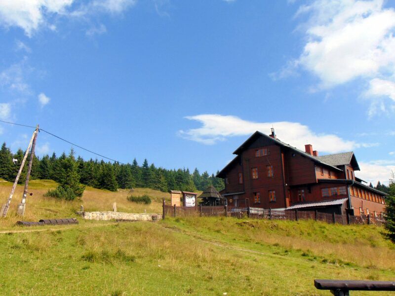 Drewniany budynek schroniska górskiego.