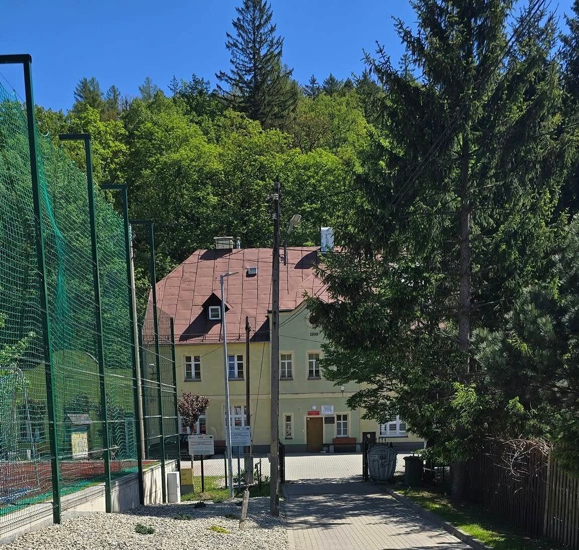 Widok na oddalony budynek schroniska.