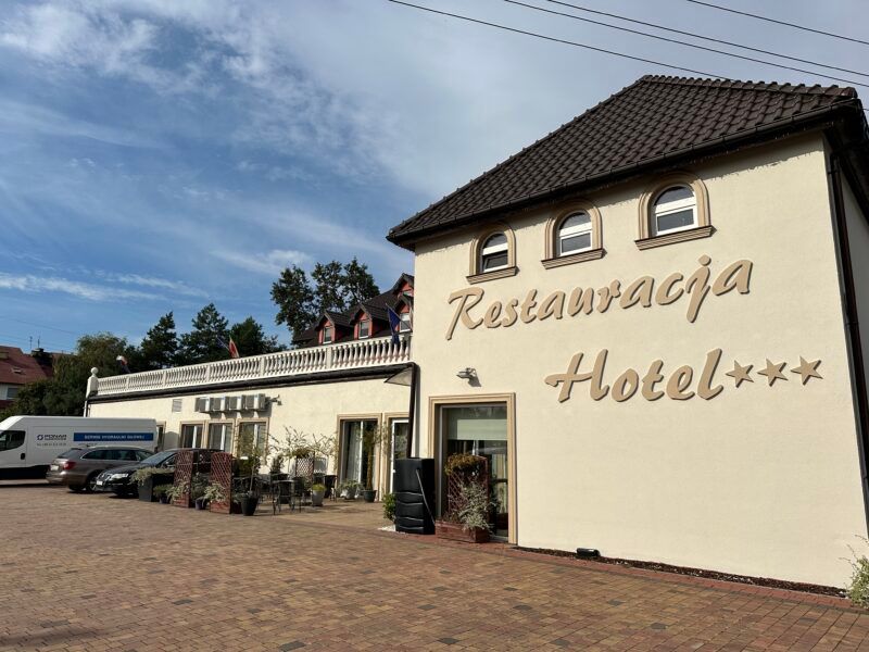 Widok na elewację frontową budynku z wielkim napisem "restauracja, hotel***"