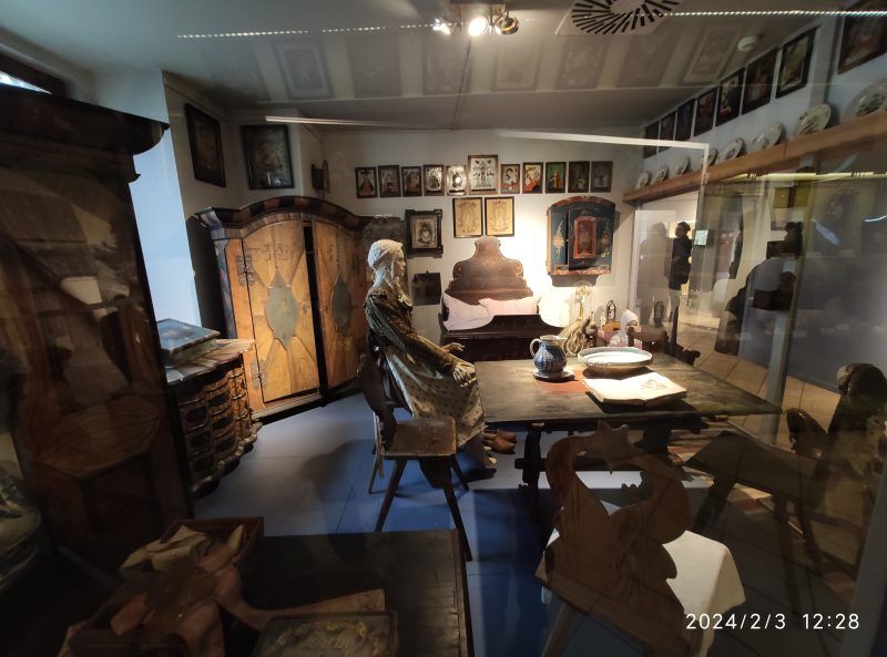 Fragment wystawy, prezentujący bogato zdobione wnętrze dawnej izby ludowej. 