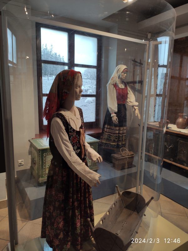 Fragment wystawy, prezentujący bogato zdobione stroje udowe.