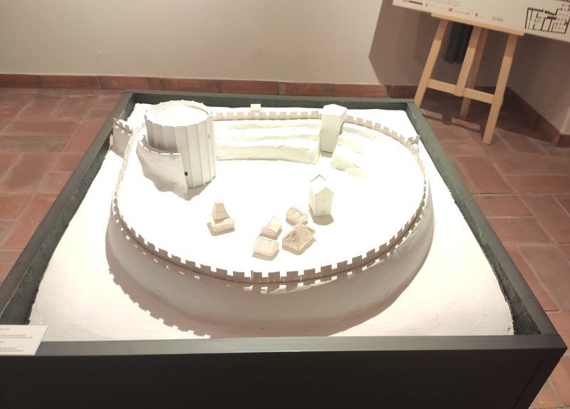 Makieta dawnej budowli obronnej z murami i wieżą. Model pokazuje układ fortyfikacji i zabudowań wewnątrz.