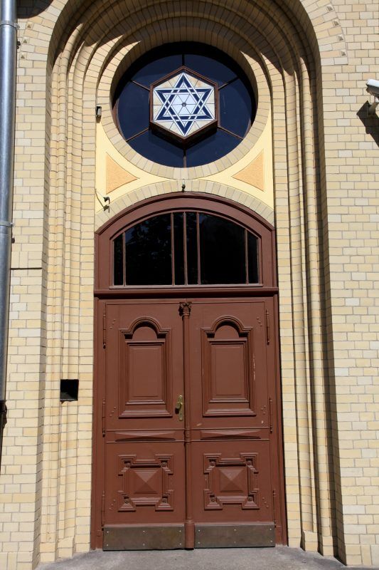 Główna wejście do synagogi z klasycystycznymi łukowym wejściem. Nad drewnianymi drzwiami rozeta z Gwiazdą Dawida.