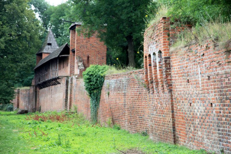 Średniowieczna konstrukcja z cegły, o solidnej budowie, z charakterystycznymi basztami i bramami, które niegdyś otaczały miasto, zapewniając mu ochronę przed najazdami.