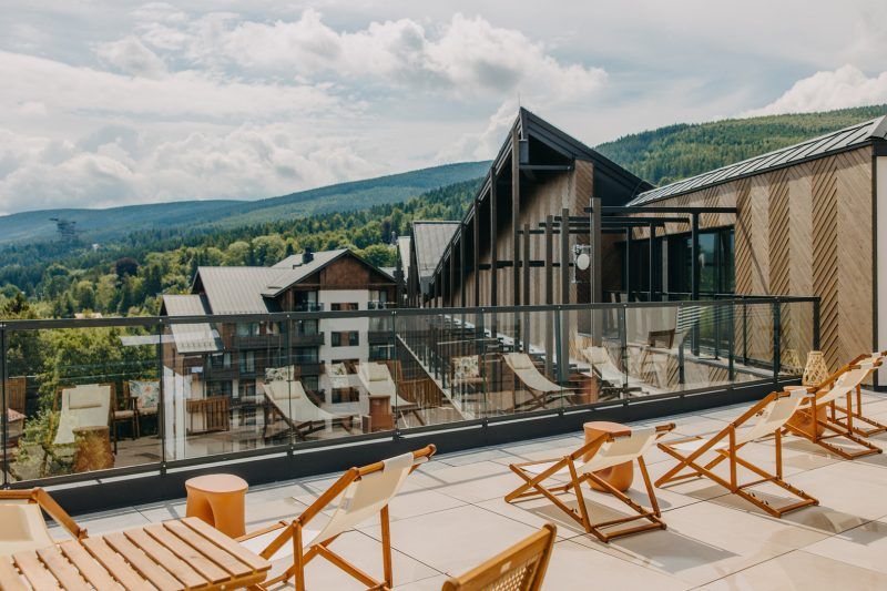 widok z tarasu na wysokim piętrze na hotel i góry