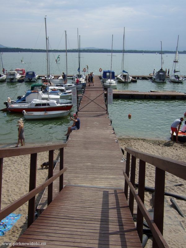 widok na krótki drewniany pomost z łodziami