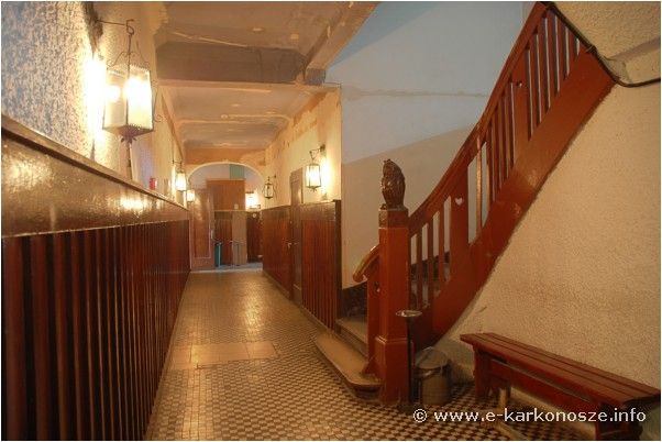 zdjęcie przedstawia drewniany korytarz w schronisku, oraz jego również drewniane schody