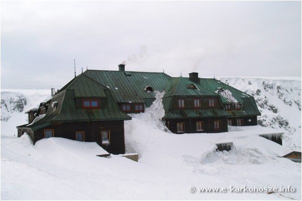 widok na schronisko otoczone i zasypane śniegiem