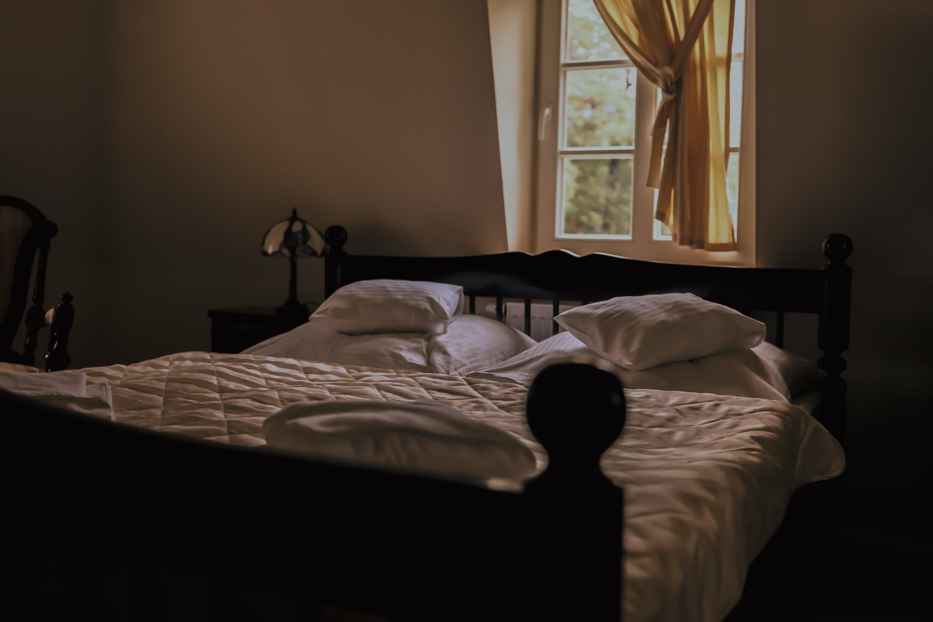 Widok na podwójne łóżko w pokoju hotelowym.