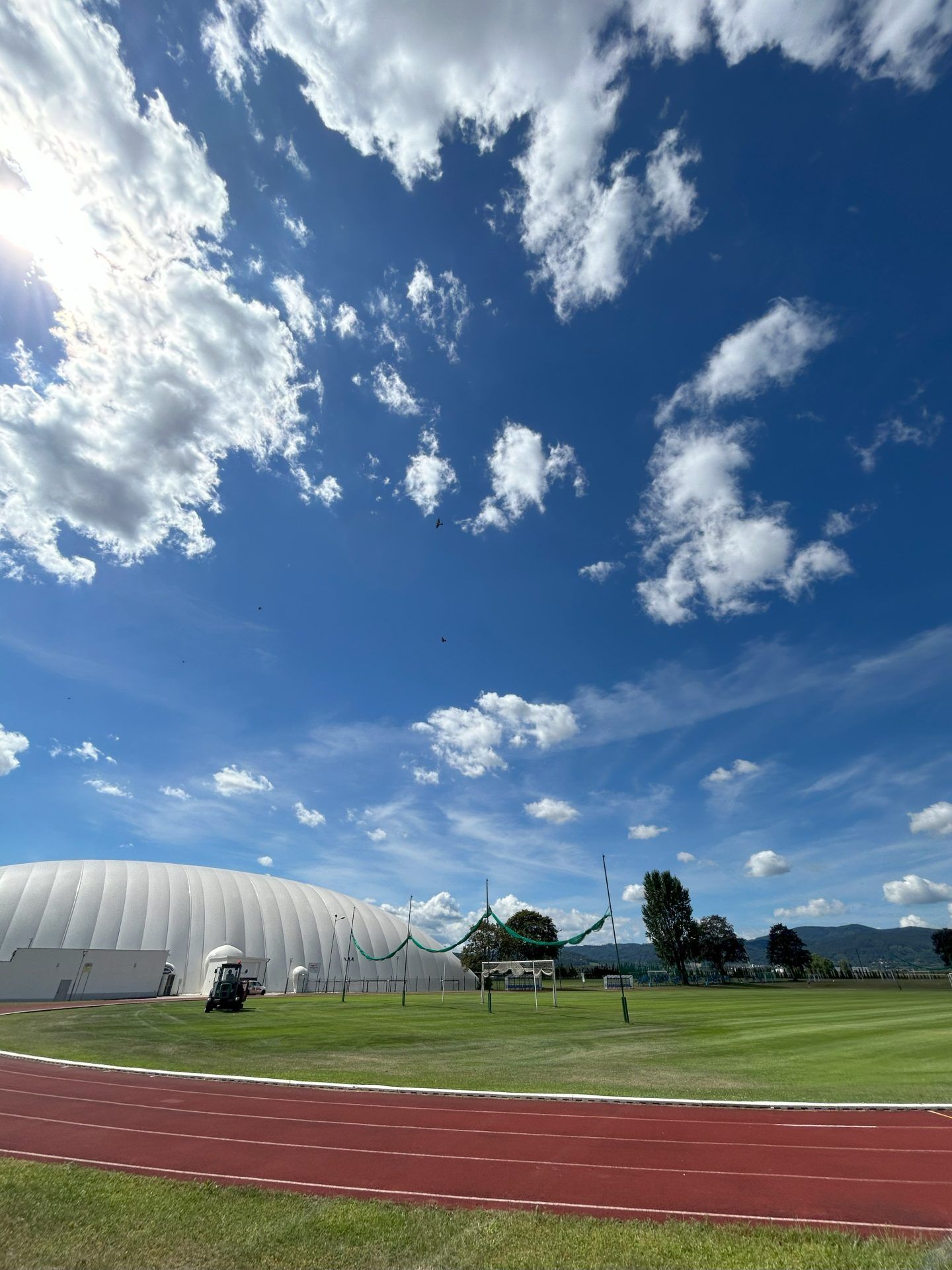 Teren sportowy — boisko pod dmuchanym sklepieniem oraz bieżnia.
