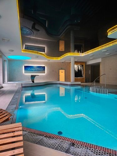 luksusowy basen hotelowy z nowoczesnym designem, podświetlanym sufitem i elegancką strefą relaksu.