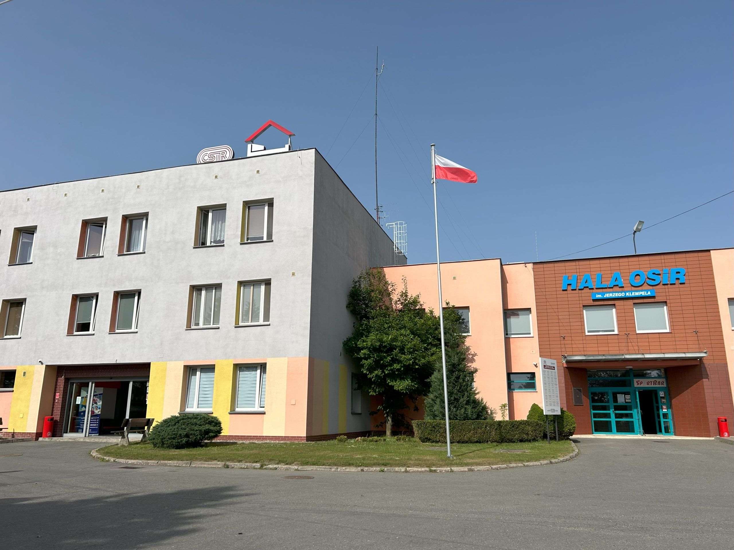 Trójkondygnacyjny blok mieszczący hotel, przylegający do hali sportowej.