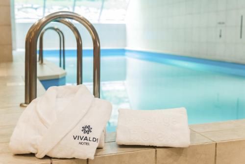 Basen wewnętrzny. Przy drabince położone ręczniki z logo i nazwą hotelu.