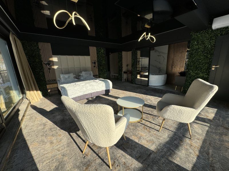 Apartament - duża dobrze doświetlona przestrzeń z podwójnym łożem, stolikiem z fotelami oraz