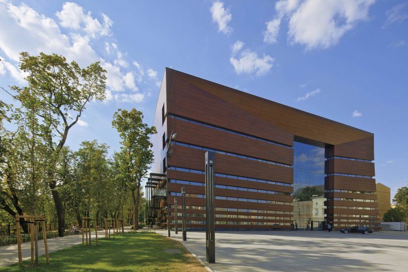 Zdjęcie przedstawia gmach filharmonii z widocznym częściowo Placem Wolności. 