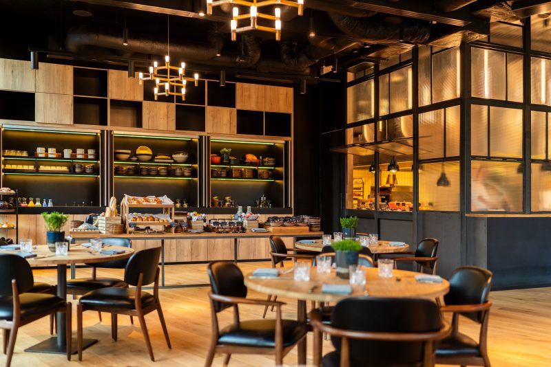 Nowoczesna, designerska restauracja, w której dominuje czerń i drewno.