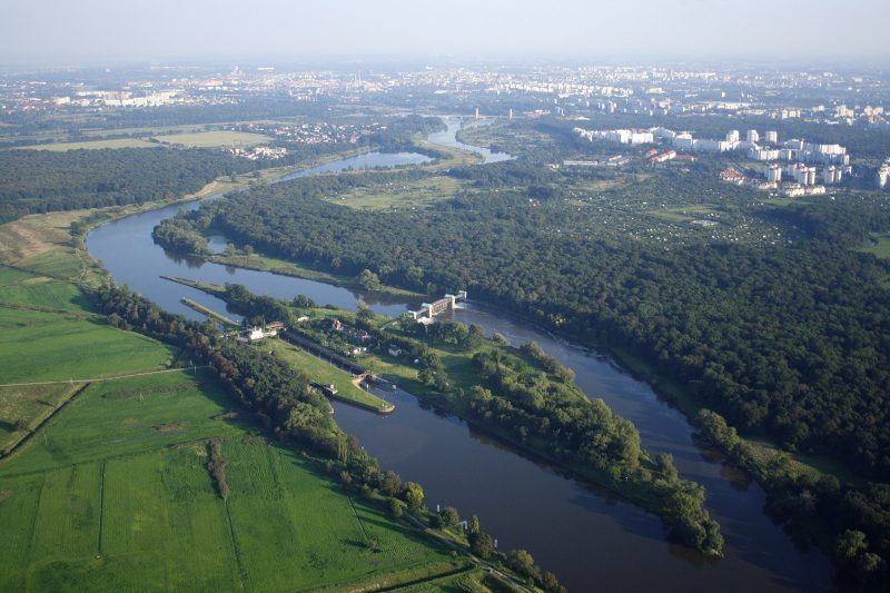 widok z drona na szeroką rzękę, na której znajduję się podłużna wyspa
