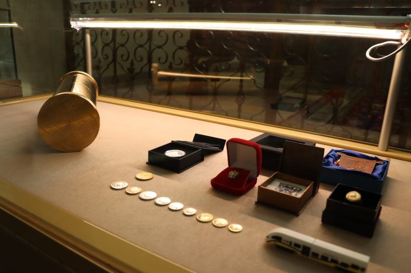 widok na podświetloną półkę z biżuterią i monetami