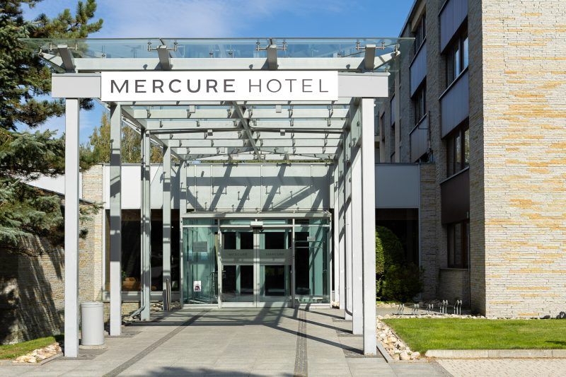 Szklany daszek prowadzi do głównego wejścia hotelu, podkreślając jego nowoczesny i elegancki charakter. Otoczenie budynku jest starannie utrzymane i harmonijnie wpisuje się w górski krajobraz.