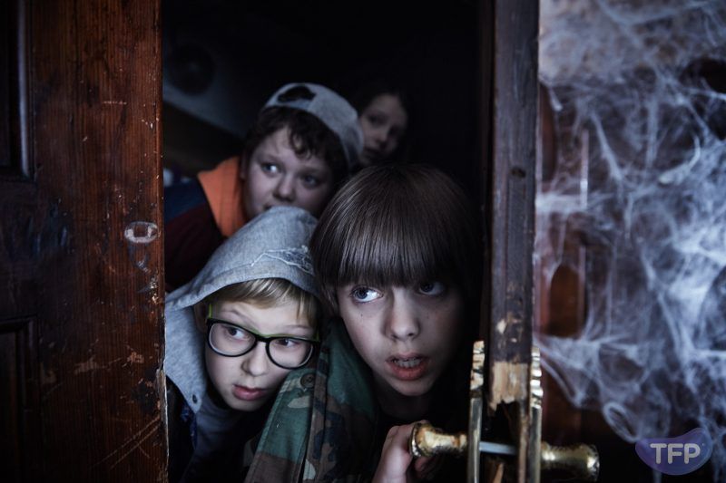 Kadr z filmu przedstawiający dzieci otwierające stare drzwi.