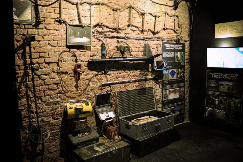 widok na narzędzia w ciemnym pomieszzeniu, powieszone na ceglanej ścianie