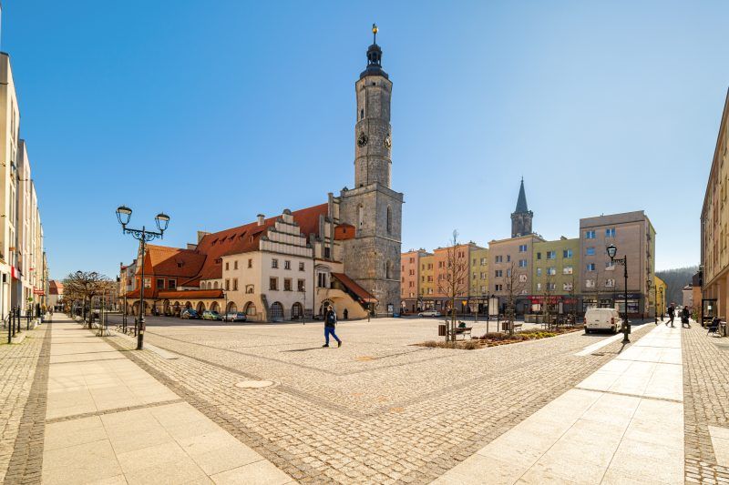 Imponujący budynek w stylu renesansowym z charakterystyczną wieżą zegarową, bogato zdobioną elewacją i strzelistymi dachami.