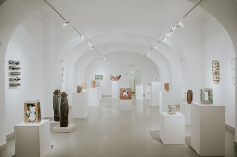 Wnętrze galerii sztuki- białe ściany z białymi cokolikami i stojącymi na nich rzeźbami