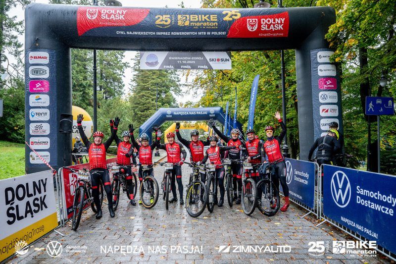 Rowerzyści stojący na starcie wyścigu pod dmuchaną bramą